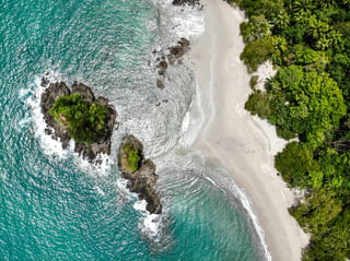 An island next to a jungle and beach in the waves