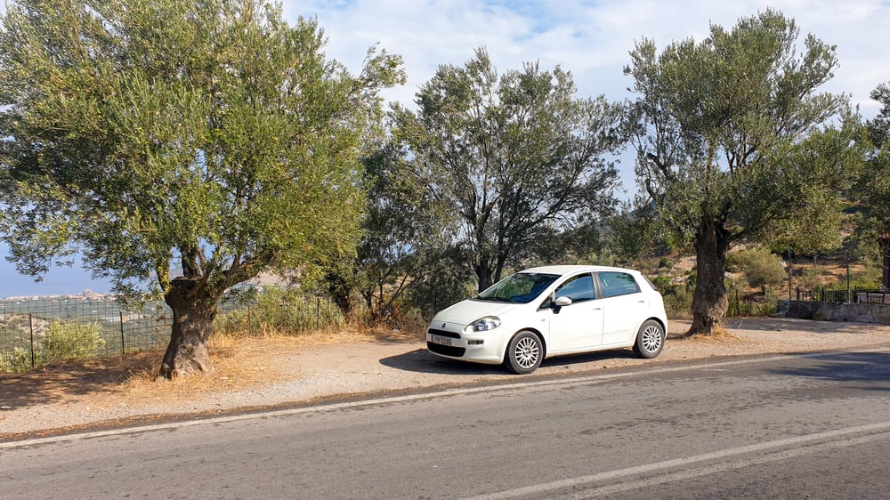 The white car was parked along the road in Lesbos.