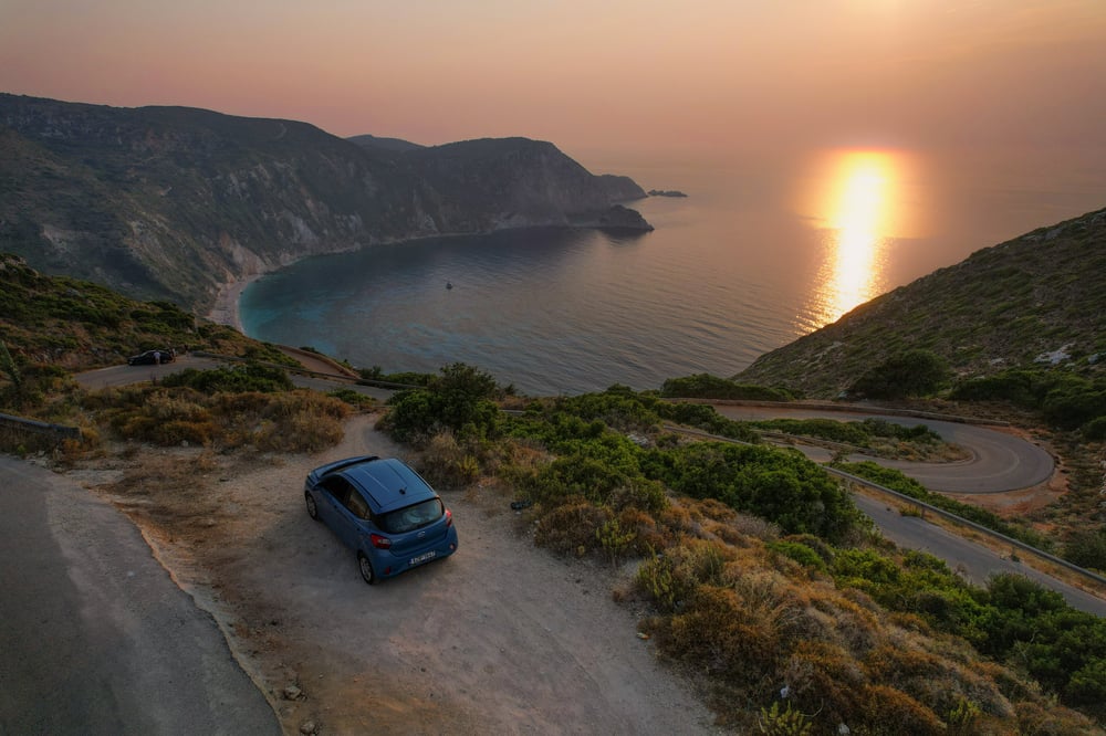 A parked car at a bay during a sunset in Greece.