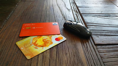 A car key, (prepaid) credit card, and a debit card on a table