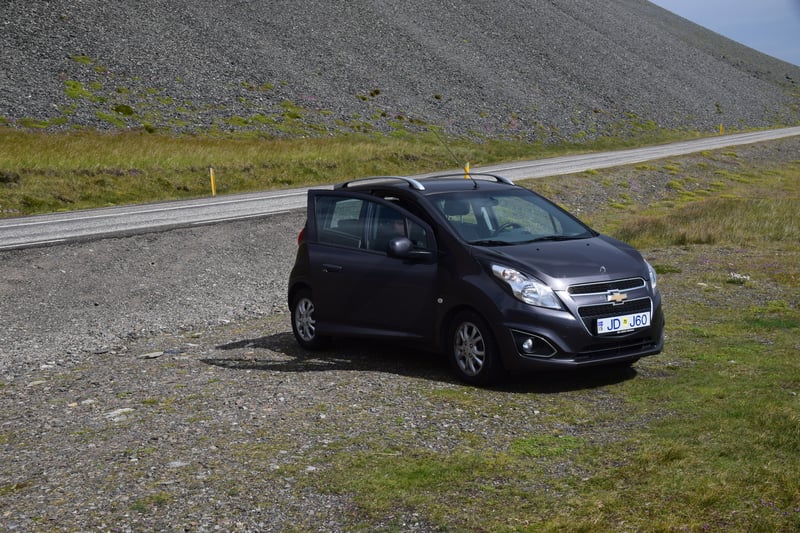 Small dark car parked next to the Ring Road