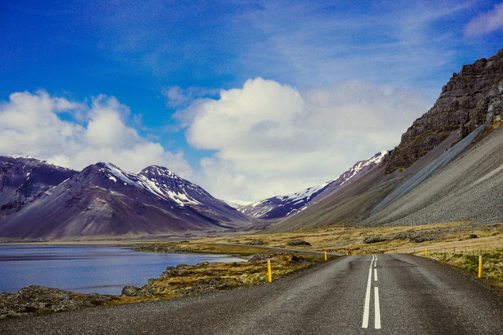Road between lake and mountains in Iceland