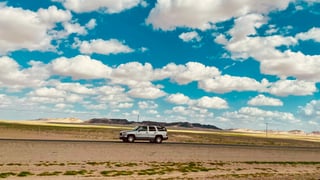 White suv on desert road in Saudi Arabia