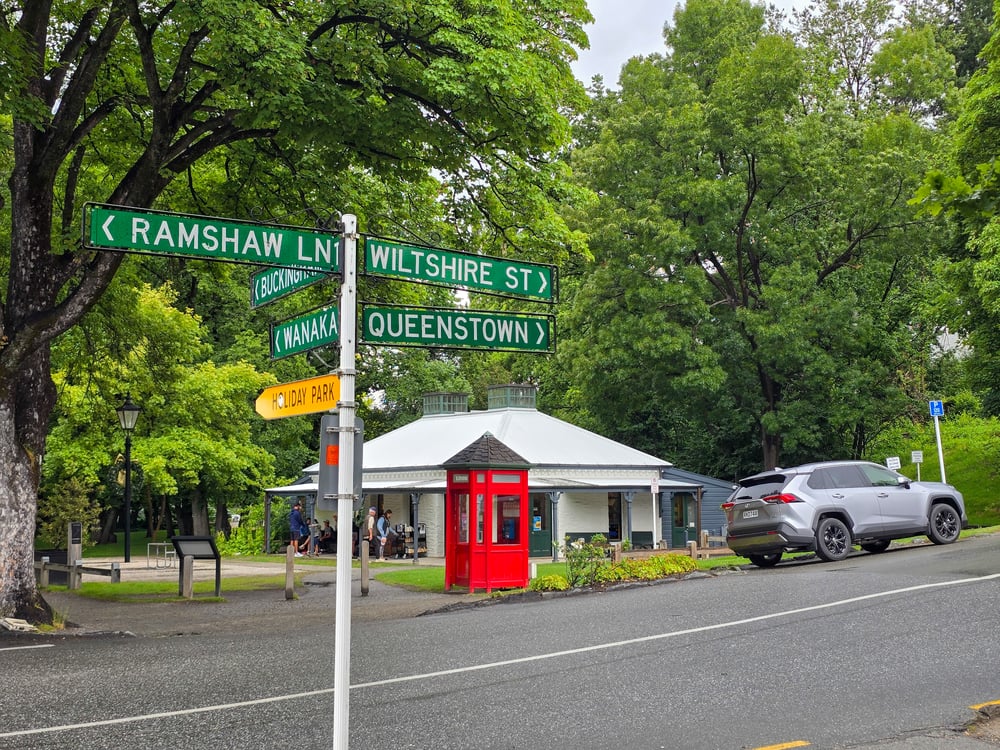 Road sign, a telephone booth and a car