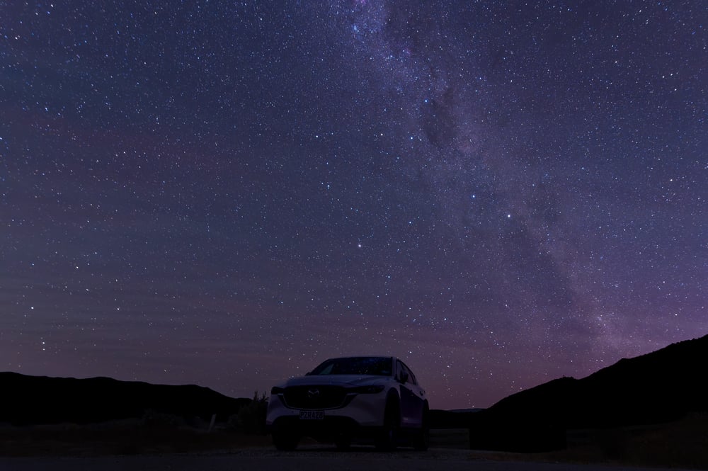 Silhouet of a car against the purple sky with stars